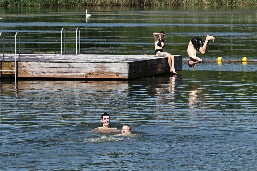 Personen beim Schwimmen und Entspannen an einem klaren Badesee in Echternach im Sommer