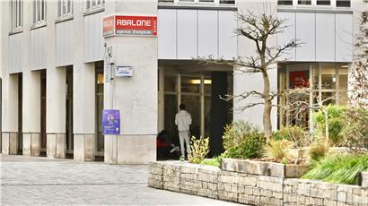 Menschen versammeln sich am späten Nachmittag unter historischen Arkaden bei warmem Licht