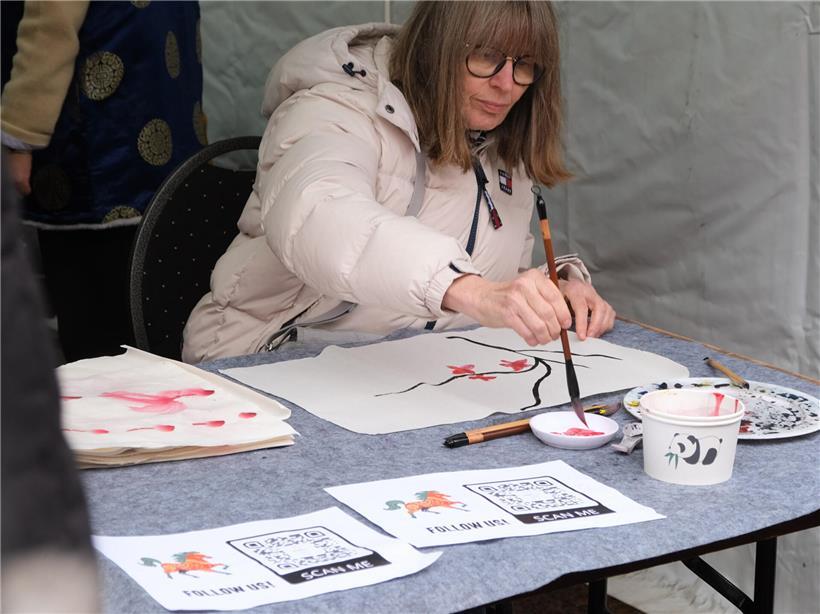 Chinesisches Neujahr 2026 in Luxemburg: Das Jahr des Feuerpferds bringt Bewegung in die Oberstadt Besucher am Stand des Konfuzius-Instituts üben chinesische Kalligrafie und traditionelle Malerei aus