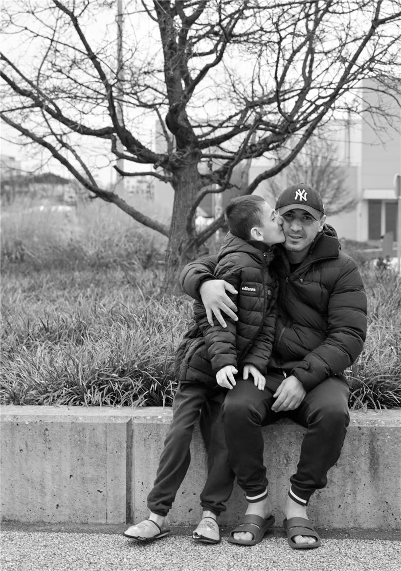 Ardwan und sein Vater Azad lachen gemeinsam im Freien, Familienfoto voller Wärme und Nähe