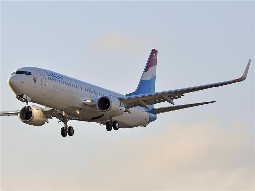 Luxair Flugzeug vor Tanklager symbolisiert beträchtliche Kraftstoffreserven zur Vermeidung kurzfristiger Preisspitzen