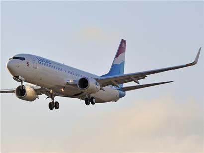 Luxair Flugzeug vor Tanklager symbolisiert beträchtliche Kraftstoffreserven zur Vermeidung kurzfristiger Preisspitzen