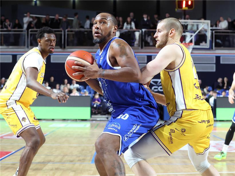 Billy McDaniel bei spannendem Basketballspiel gegen Etzella, entscheidender Korb und jubelnde Spieler