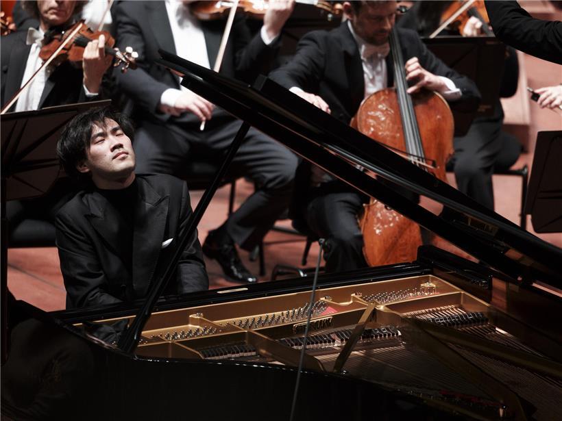 Bruce Liu spielt konzentriert Klavier als Solist bei klassischem Konzert, beeindruckt mit virtuosem Pianospiel