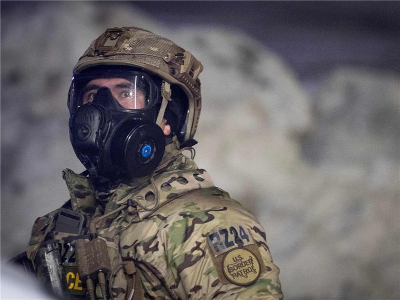 Bundesbeamte im Einsatz in Minnesota mit Schutzwesten und Ausrüstung vor städtischem Hintergrund