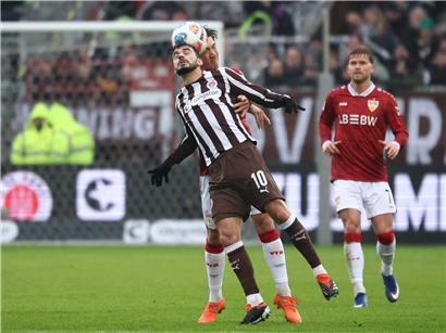 Danel Sinani entspannt sich kurz während eines Fußballspiels, zeigt Erschöpfung und Konzentration auf dem Spielfeld