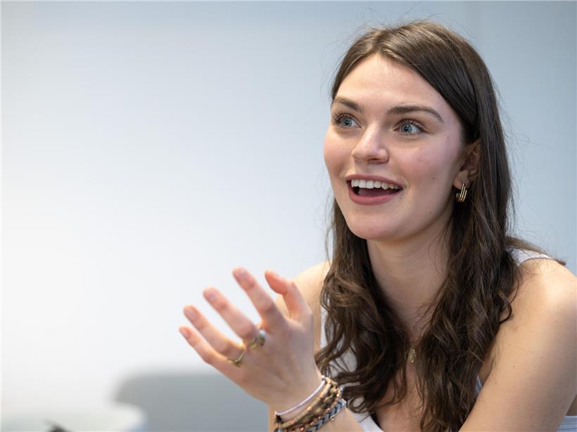 Eva Marija lächelt strahlend, zeigt Freude und positive Ausstrahlung in natürlicher Umgebung.