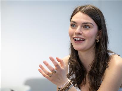 Eva Marija lächelt strahlend, zeigt Freude und positive Ausstrahlung in natürlicher Umgebung.