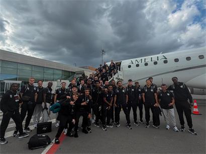 Team posiert vor Abflug für Erinnerungsfoto am Flughafen, Reiseteam bereit für Flugreise
