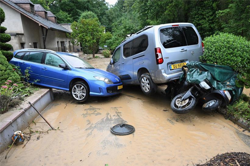 Das Wasser hat mehrere geparkte Autos ineinander geschoben