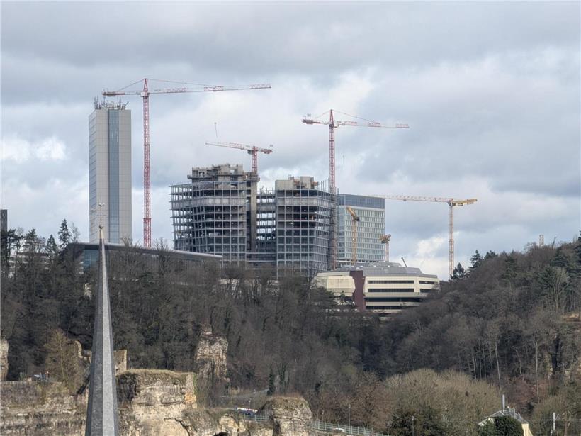 Bau des neuen Firmensitzes im fortgeschrittenen Stadium mit Baukränen und Arbeitern auf der Baustelle