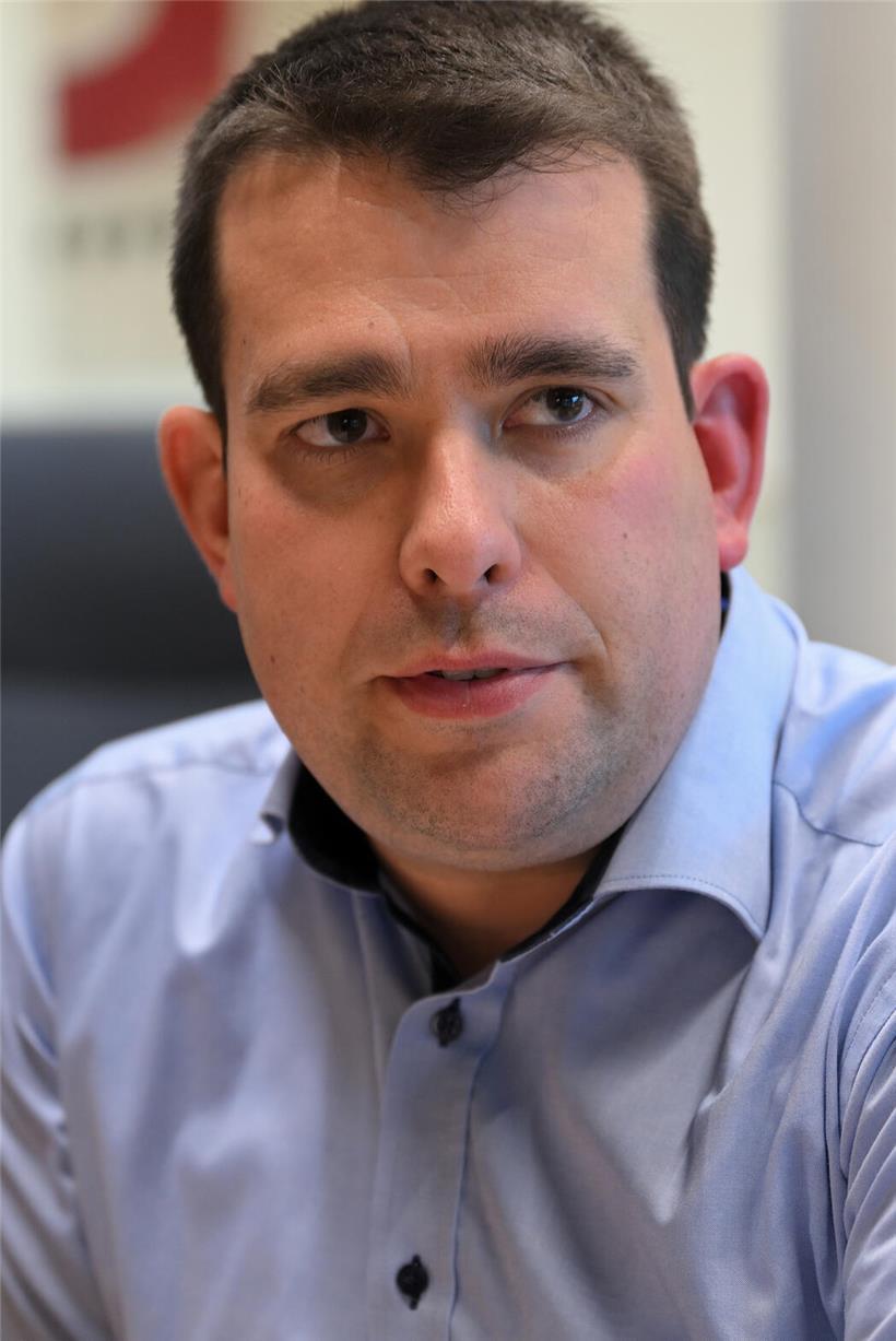 Porträt von Fréd Ternes, Bürgermeister von Niederanven (CSV), in formeller Kleidung vor neutralem Hintergrund