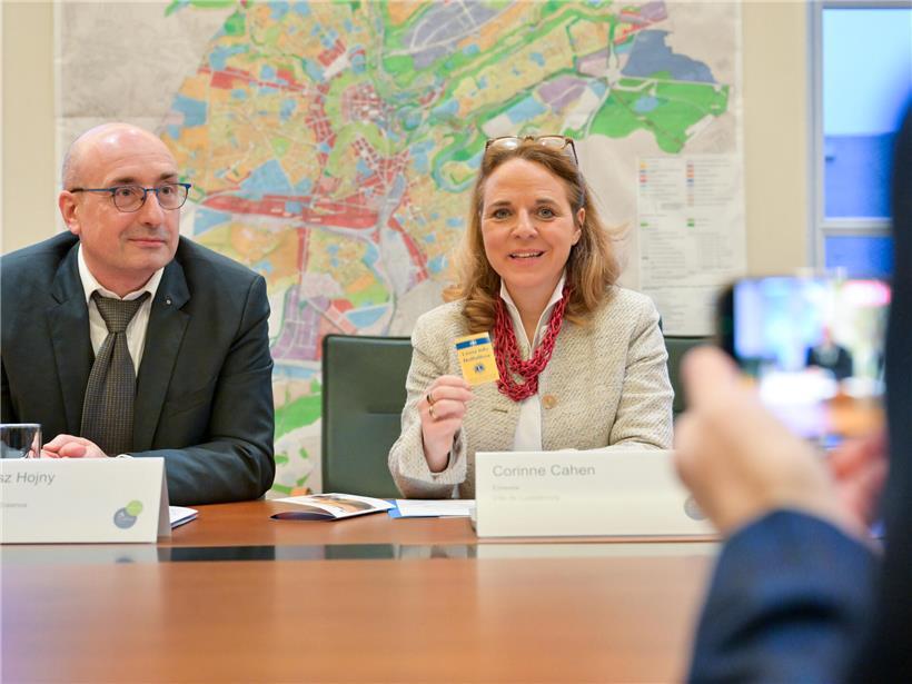 Dr. Arkadiusz Hojny und Corinne Cahen präsentieren Lions Club Erasmus Sticker für Eingangstür und Kühlschrank