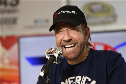 Porträt von Chuck Norris, berühmter Schauspieler und Kampfkünstler, in nachdenklicher Pose vor dunklem Hintergrund