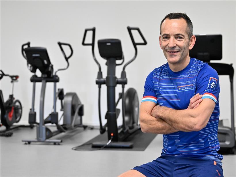 Trainer übergibt Louis wöchentlich individuellen Trainingsplan für effektives Fitnessprogramm