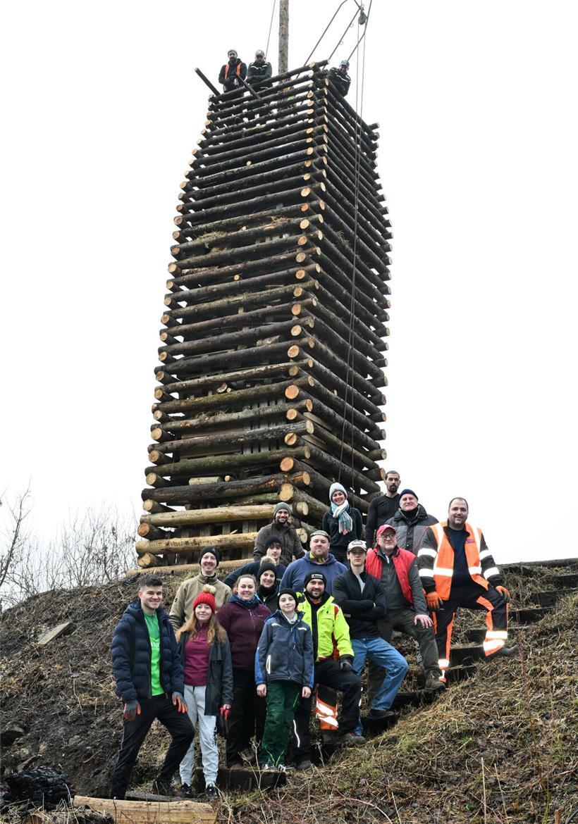 Burgbauer stehen vor ihrem 10 Meter hohen robusten Holzturm auf dem historischen Burggelände