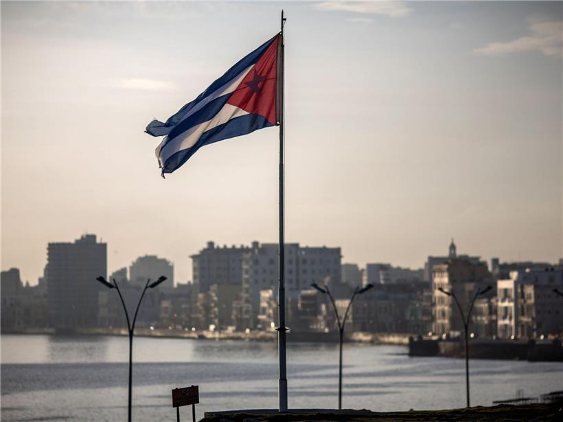 Kubas Flagge weht vor der Skyline der Hauptstadt Havanna bei klarem Himmel