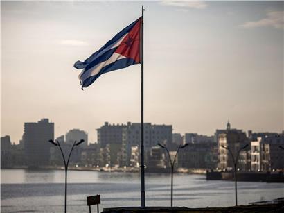 Kubas Flagge weht vor der Skyline der Hauptstadt Havanna bei klarem Himmel