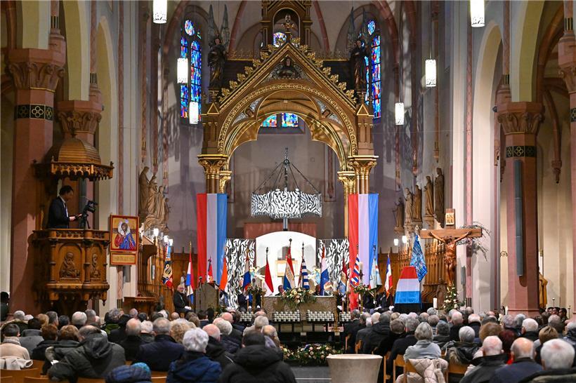 Gedenkzeremonie in der historischen Pfarrkirche von Diekirch mit versammelten Teilnehmern und Kerzenlicht