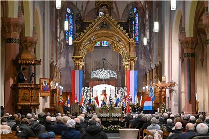 Gedenkzeremonie in der historischen Pfarrkirche von Diekirch mit versammelten Teilnehmern und Kerzenlicht