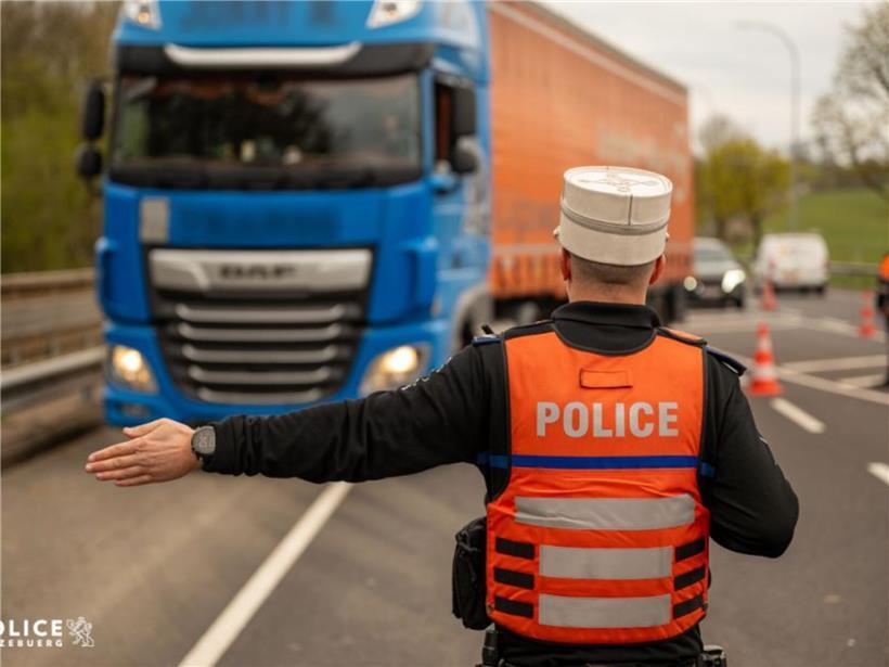 Polizeikontrolle von Lkw-Fahrern auf der Straße zur Überprüfung von Transport- und Sicherheitsvorschriften