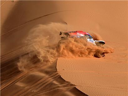 Rallye Dakar Offroad-Rennwagen in Aktion bei spektakulärer Wüstenfahrt auf staubiger Strecke