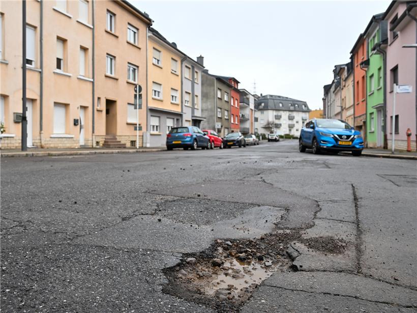 Straße mit Schlaglöchern, die alle vier bis fünf Wochen von Einwohnern regelmäßig ausgebessert werden