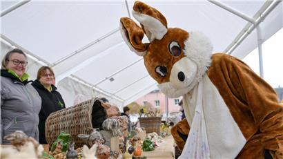 Osterhase bei Frühlingsveranstaltung am Wochenende, Familienfest mit bunten Osteraktivitäten und fröhlicher Stimmung