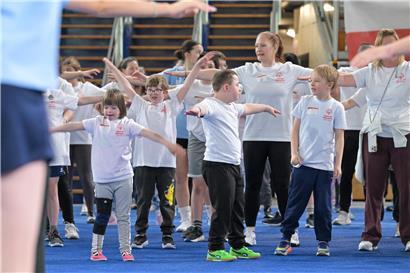 Viele Teilnehmer genießen gemeinsam eine spaßige Veranstaltung im Freien mit sonnigem Wetter und guter Stimmung.
