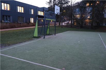 Fußballfeld mit angrenzendem neu angelegtem Basketballplatz in grüner Sportanlage