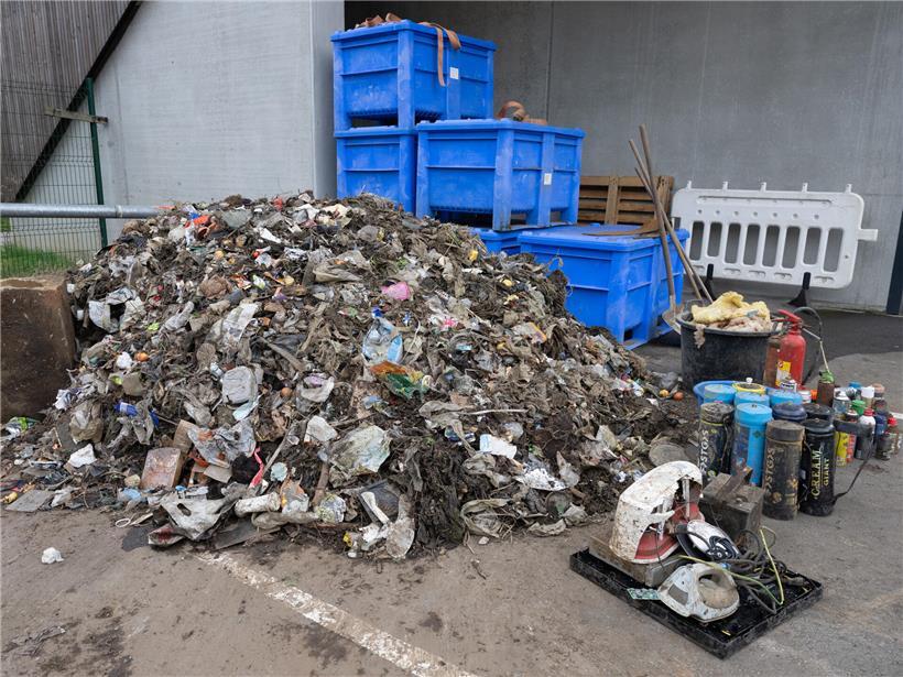 Haufen Müll liegt am Ufer, kürzlich aus dem Wasser geborgen, Umweltschutz und Gewässerverschmutzung sichtbar