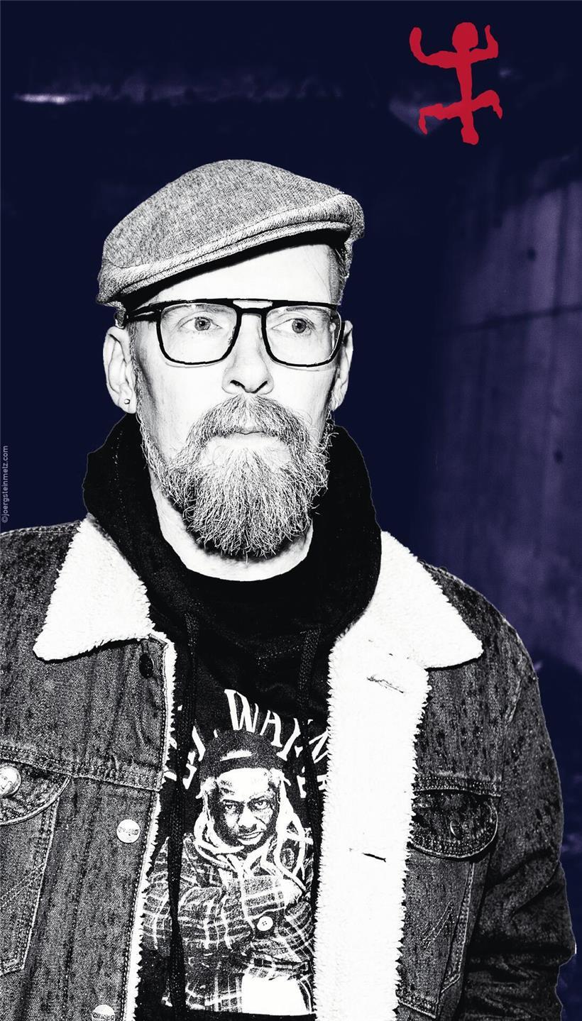 Dietmar Dath: Skyrmionen – Sprache, KI und literarische Höchstleistung Dietmar Dath vor dynamischem Hintergrund, der kreative Grenzen in Literatur und Wissenschaft symbolisiert