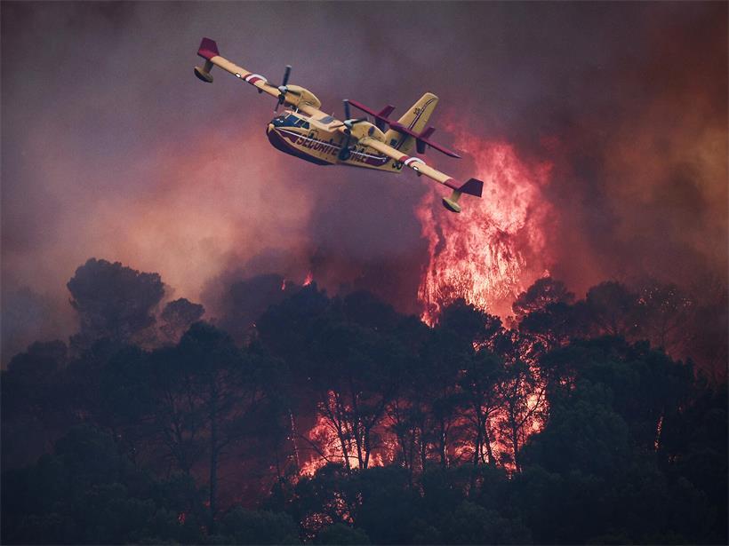 Ein Flugzeug des französischen Zivilschutzes vom Typ Canadair CL-415 fliegt während eines Waldbrands an den Flammen vorbei