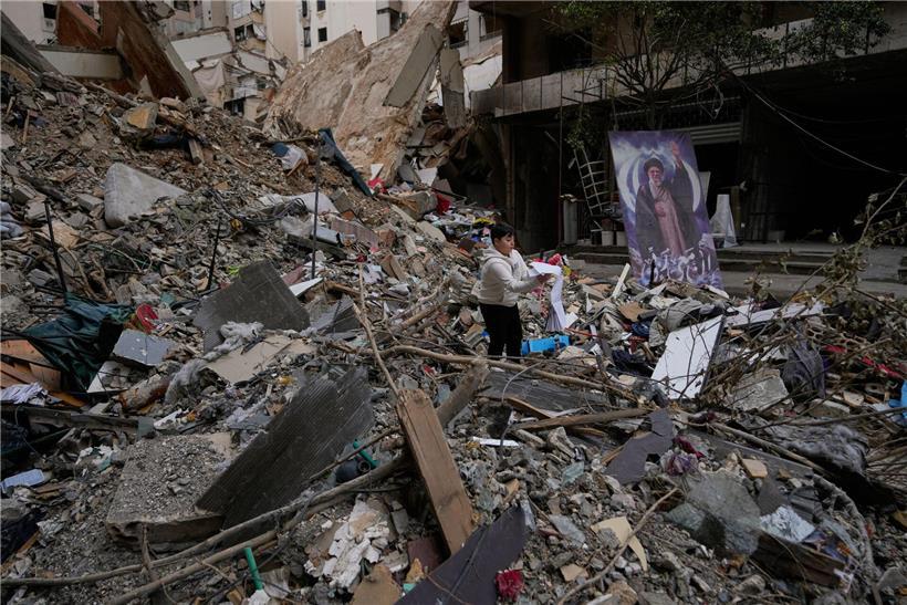 Junge hält Schulbuch in Trümmern nach Waffenstillstand zwischen Hisbollah und Israel in Dahiyeh, Beirut