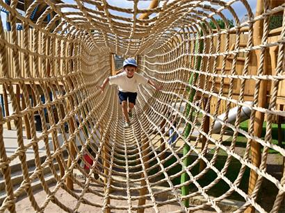 Ein Junge testet den Seiltunnel – eine von vielen Klettergelegenheiten