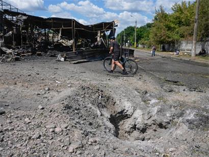 Ein Mann geht nach einem russischen Raketenangriff in Kiew (Ukraine) an einem Raketenkrater auf dem Marktplatz der zerstörten Stadt vorbei