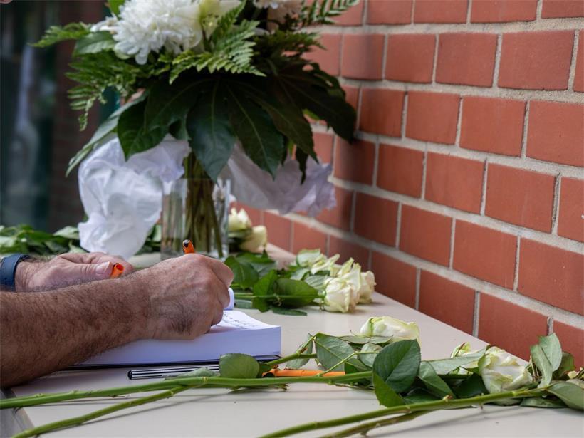 Ein Mann trägt sich in das Kondolenzbuch für Marius Dick ein. Der 22-jährige Student war in der vergangenen Woche bei einem Messerangriff tödlich verletzt worden.