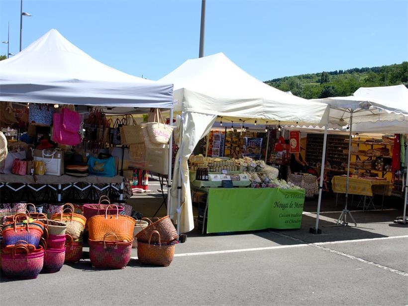 Bunter südfranzösischer Markt mit frischem Obst, Gemüse und regionalen Spezialitäten unter blauem Himmel