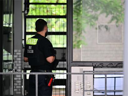 Ein Polizeibeamter im Hauseingang des Wohnblocks, wo in der Nacht eine Wohnung durchsucht wurde