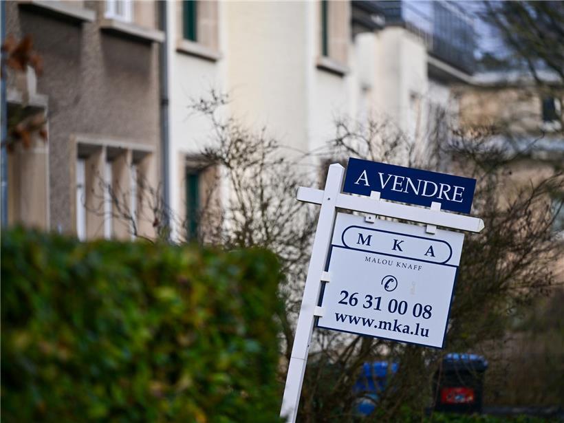 Verkaufsschild vor einem Haus in Luxemburg mit grünem Garten, Immobilienangebot in Luxemburg Stadt
