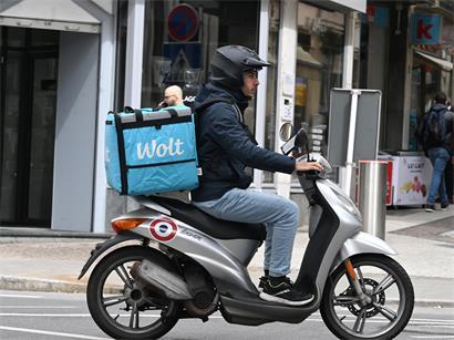 Wolt-Lieferfahrer in Luxemburg liefert Essen aus, Symbol für Essenslieferung und Fahrerbezahlung in der Gig Economy