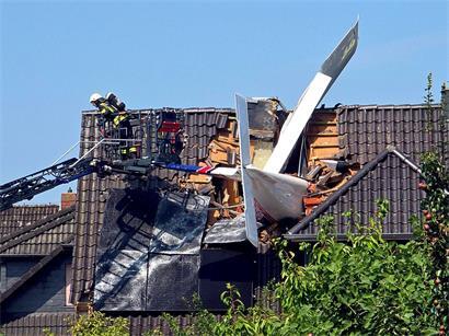 Ein abgestürztes Leichtflugzeug steckt im Dach eines Hauses