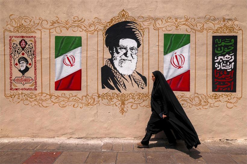Eine Frau läuft in Teheran am Porträt des getöteten ehemaligen iranischen Präsidenten Ali Khamenei vorbei