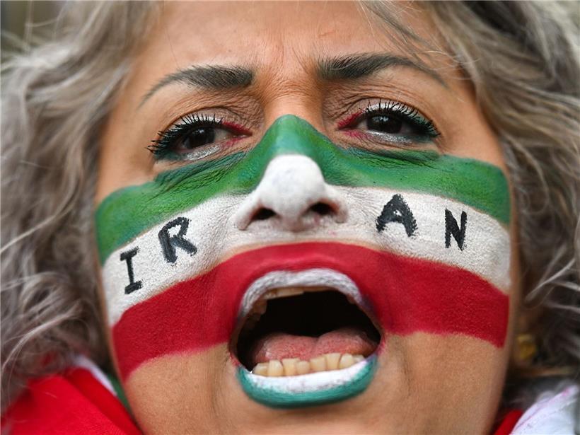 Frau mit iranischen Nationalfarben im Gesicht ruft bei Protestkundgebung gegen Regierung im Iran