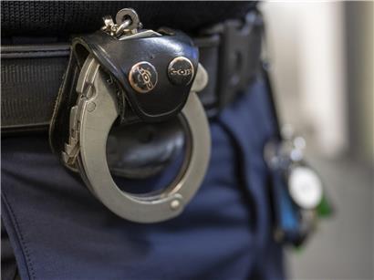 Polizist mit Handschelle am Gürtel in Uniform, Symbol für Sicherheit und Strafverfolgung