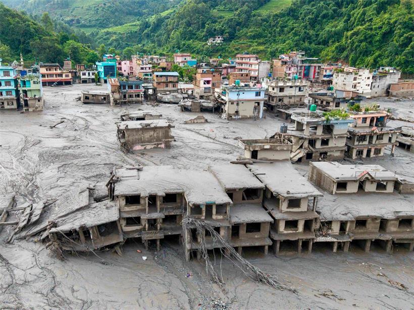 Eine Luftaufnahme zeigt Häuser, die nach Sturzfluten am 27. August 2026 in Devighat, Gemeinde Bidur, im nepalesischen Distrikt Nuwakot unter Schlamm begraben sind