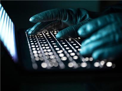 Person mit Handschuhen tippt auf beleuchtete Laptop-Tastatur, Arbeit im Dunkeln, ergonomisches Tippen, Technologie nutzen