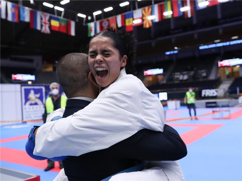 Karatekämpferin in weißem Gi bei letztem Wettkampfmoment ihrer Karriere in dynamischer Kampfhaltung