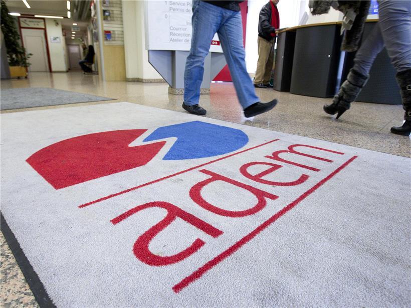 Antragsteller warten geduldig auf die Bewilligung und Auszahlung ihres Arbeitslosengeldes in einem Büro.