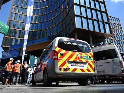 Einsatzkräfte stehen vor dem Gebäude bei einem Brand in der Brüsseler Innenstadt
